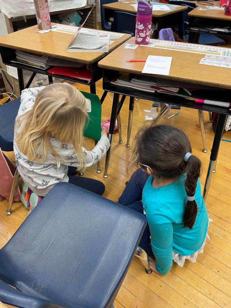 Two students are shown measuring their desks using non-standard units.